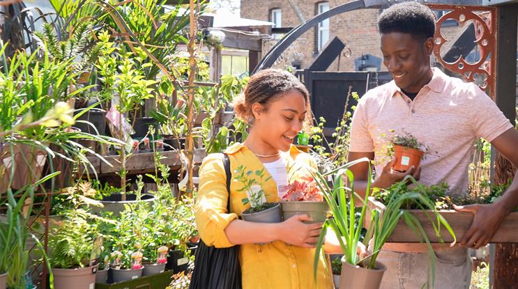 Two customers carrying plants in pots